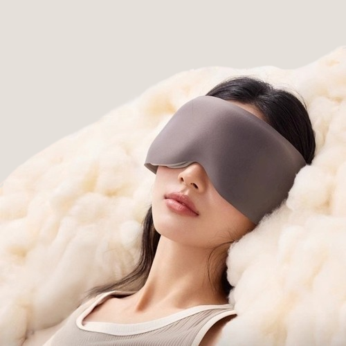 A woman wearing a weighted sleep mask resting on soft clouds for deep pressure stimulation and anxiety relief